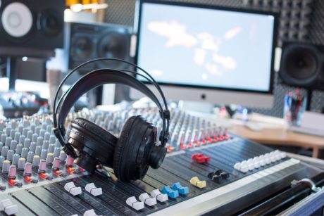 headphones on top of mixer in music production studio