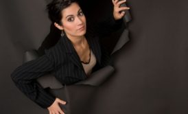 woman breaking out of hole in a brown wall