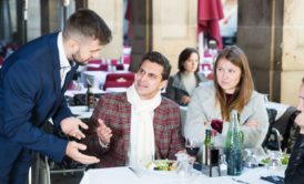 waiter in blue suit dealing with two angry customers