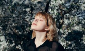 woman closing her eyes relaxing and staring at the sky