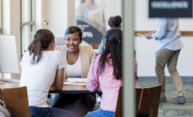 three female colleagues talking in the workplace