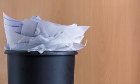 a pile of paper inside a black trash can