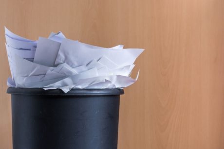 a pile of paper inside a black trash can
