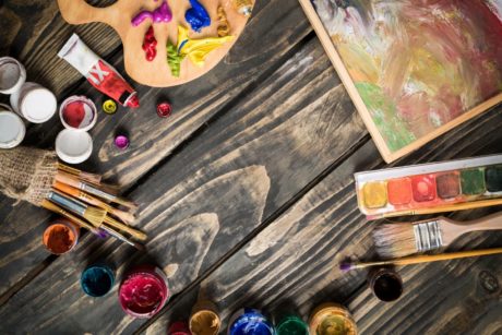 acrylic paints and palettes on wooden floor