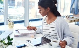 female blogger writing on notepad