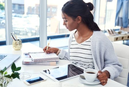 female blogger writing on notepad