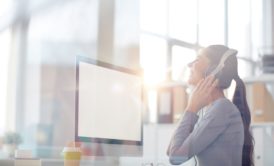 corporate music composer listening on white headphones