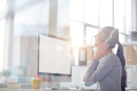 corporate music composer listening on white headphones