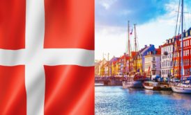 flag of denmark and danish buildings lined up by the riverside