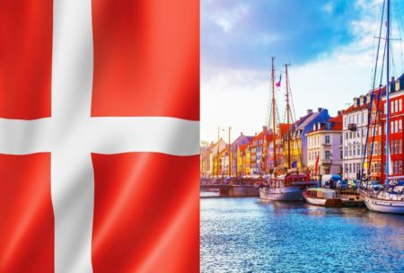 flag of denmark and danish buildings lined up by the riverside