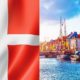 flag of denmark and danish buildings lined up by the riverside