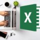 microsoft excel logo beside image of man typing on silver laptop