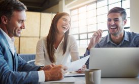 team of three professionals laughing and working together