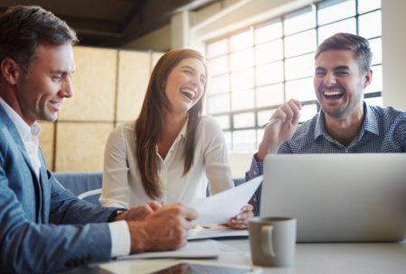 team of three professionals laughing and working together