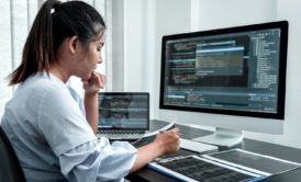 female javascript developer coding on white desktop computer