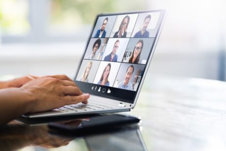 a person engaged in a video chat on a laptop, illustrating the concept of webinar marketing in action.