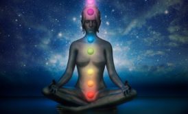 graphic illustration of a woman sitting and meditating with aligned chakras