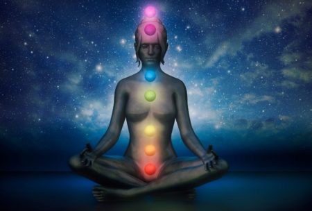 graphic illustration of a woman sitting and meditating with aligned chakras