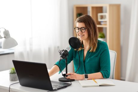 woman in green top recording a podcast