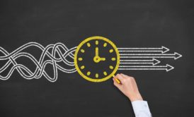 person drawing a yellow clock on chalkboard