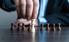 man holding a white king chess piece