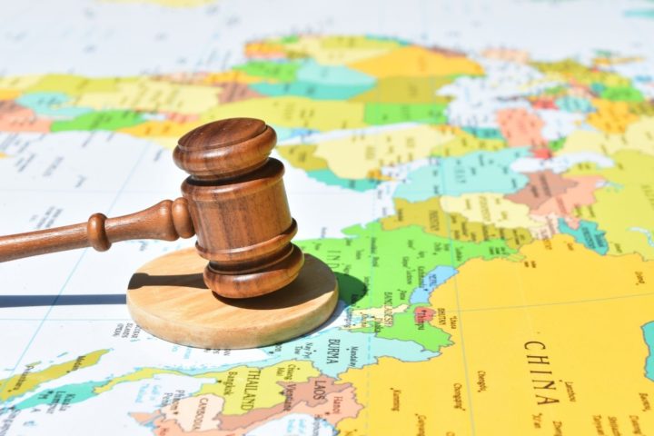 map of the world and a small wooden gavel and hammer