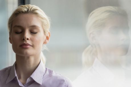 blonde woman closing eyes and meditating