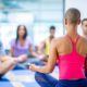 female instructor leading a group of people in a seated meditation