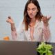 woman in white top talking to someone virtually through laptop