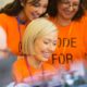 female nonprofit workers wearing orange uniform
