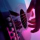 close up of hand plucking guitar strings