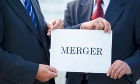 two men wearing suits holding white paper with the word merger