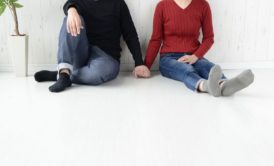 man in black sweater holding hand of woman in red sweater