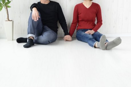 man in black sweater holding hand of woman in red sweater