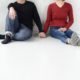 man in black sweater holding hand of woman in red sweater