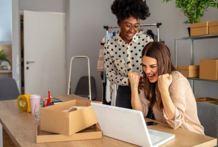 two happy women working on office desk