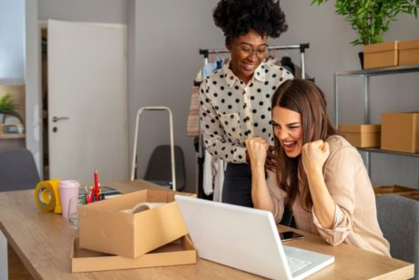 two happy women working on office desk