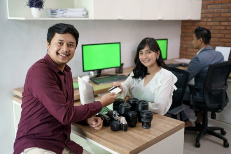 photo of smiling man and woman exchanging goods