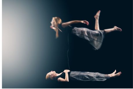 photo of woman in a gray dress looking at her own astral projection