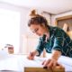 female entrepreneur wearing green plaid top in wood workshop