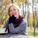 smiling woman wearing purple sweater and scarf outdoors