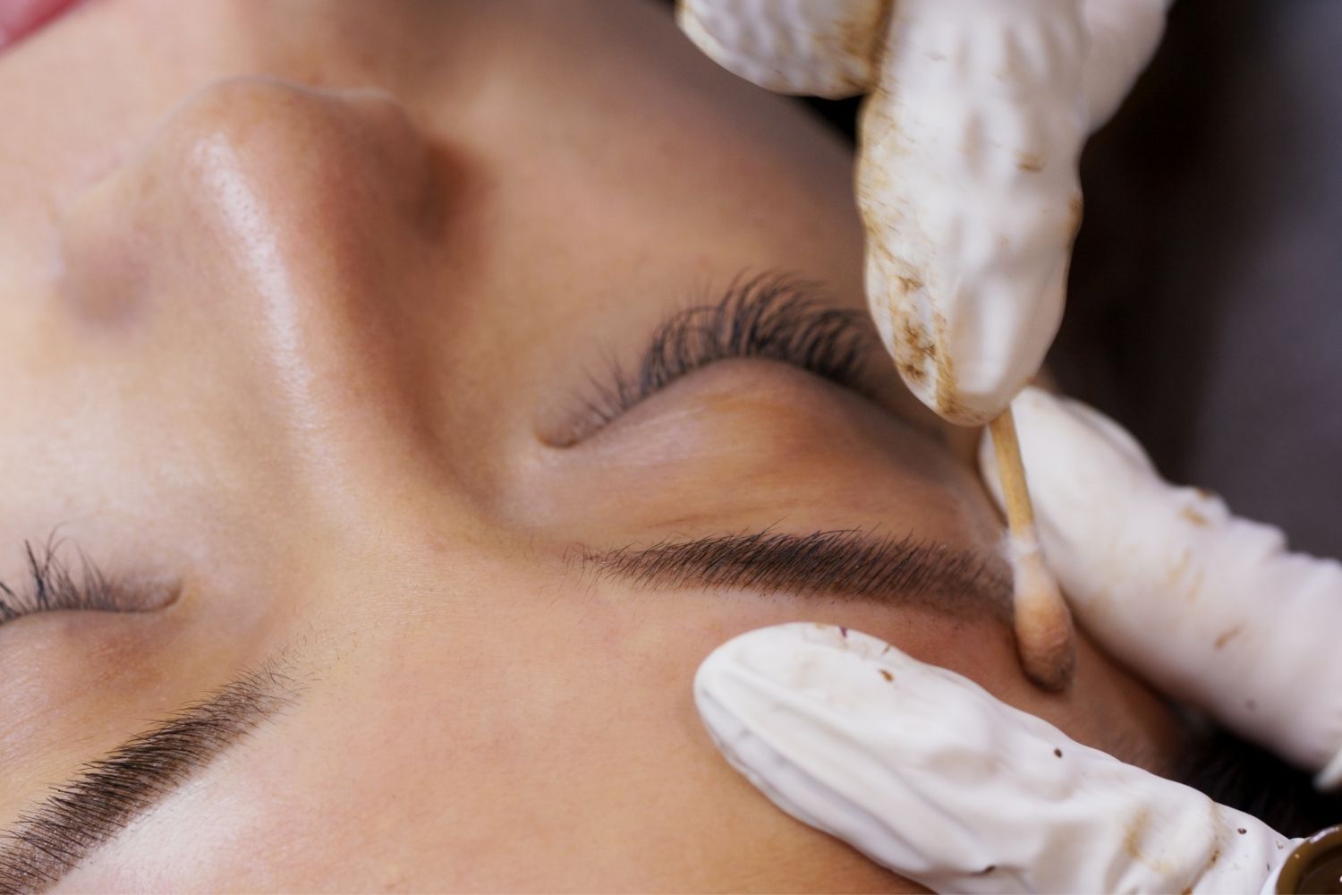 brow lamination being performed on woman's face