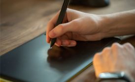 woman's hand drawing on a digital drawing tablet