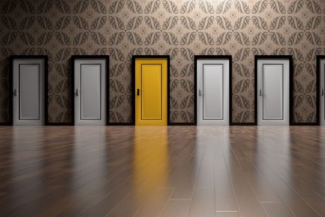 a row of white doors with a golden door in the middle