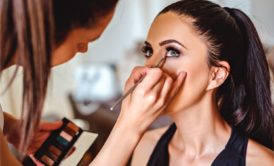 makeup artist applying makeup on woman wearing black top