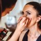 makeup artist applying makeup on woman wearing black top