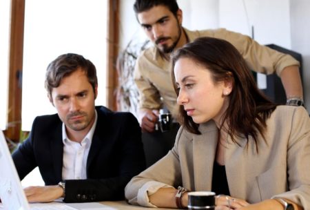 team of three people looking at a document