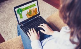 woman in white top creating restaurant website on black laptop