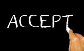 hand writing the word accept on blackboard