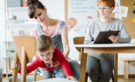 mother in denim jumpsuit helping son with adhd